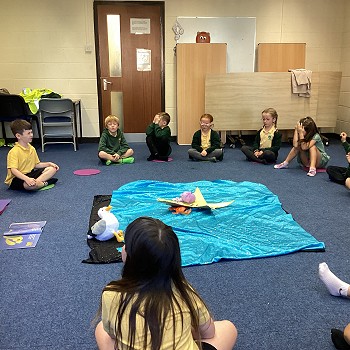 children siting in a circle around a blanket with a star