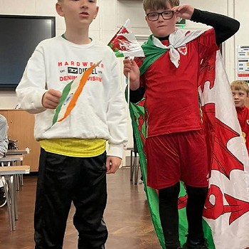 Two children holding an Welsh and India flag