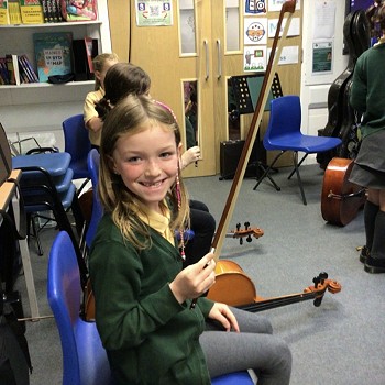 child showing off the bow of a violin