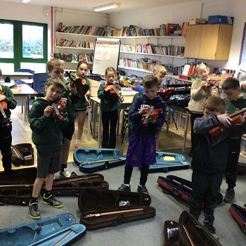 tutor and children playing violins