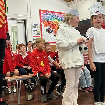 Group of girls wearing sheep outfit as part of a scene in the assembly