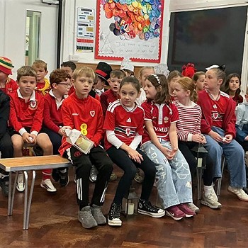 Children wearing red and is sitting o a bench