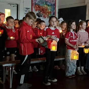 Children holding candles in the dark as part of the assembly