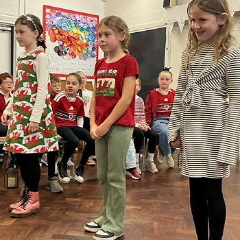 Three girls taking part in the year 3 and 4 assembly